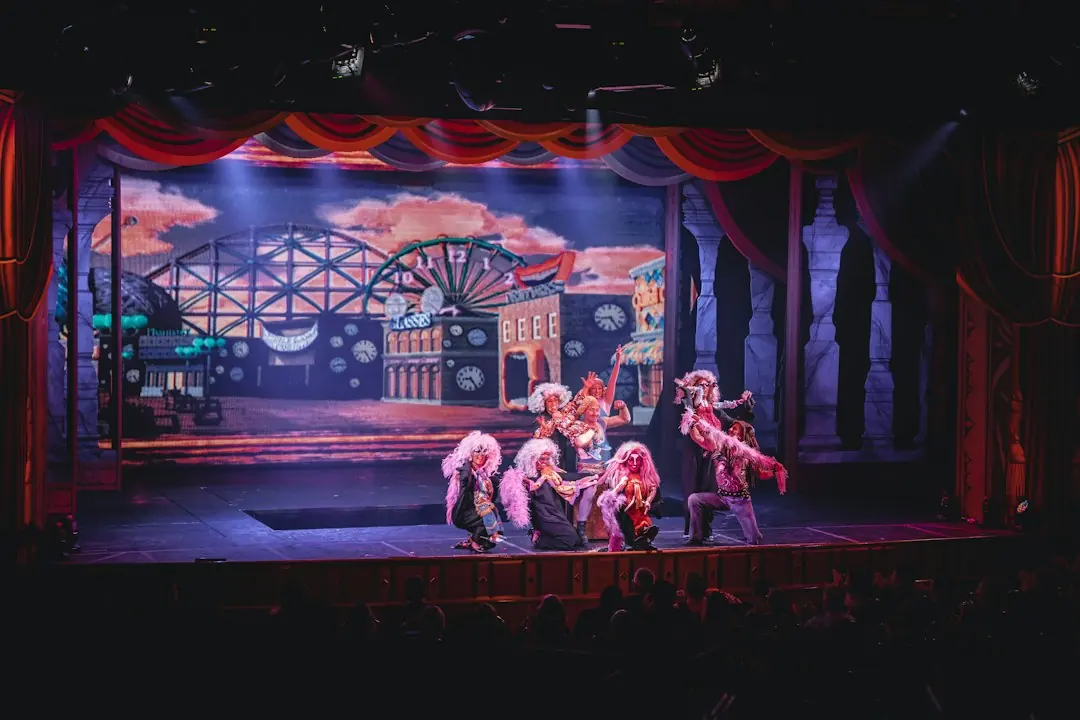 Kostümierte Künstler auf einer Theaterbühne mit bunten Kulissen während einer Show vor Publikum