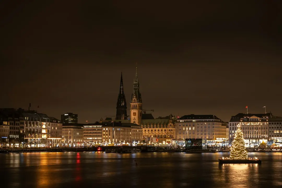 Nächtlich beleuchtete Hamburger Binnenalster mit Rathausmarkt und festlich geschmücktem Weihnachtsbaum auf dem Wasser