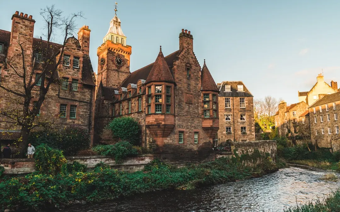 Historische Steingebäude am Fluss Water of Leith im Dean Village in Edinburgh bei herbstlichem Abendlicht